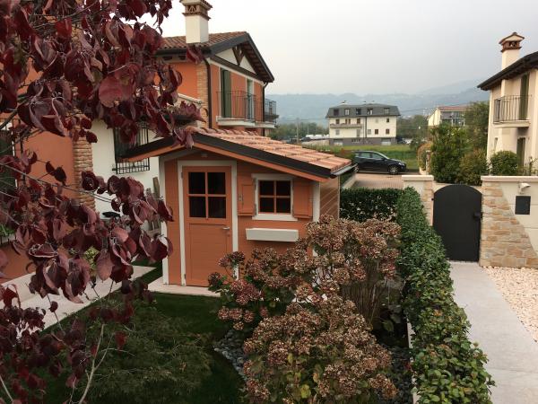 FOTO 18 casetta a pareti colorata cm 250x200 con aggiunta di : laccatura pesca, bordi bianchi, finestra fissa sulla porta, scuretti sulla finestra, fioriera, copertura coppo roofy, grondaie.